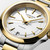Longines Conquest L3.460.3.12.7 Swiss Made 34 mm quartz watch with a white sandblasted dial, stainless steel case with yellow gold PVD bezel, and stainless steel bracelet with yellow gold PVD centre links.
