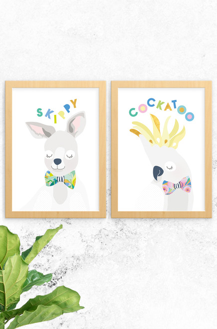 A 2-pack of prints featuring a  kangaroo named skippy and an energetic cockatoo. Both are digitally illustrated in pastel colours, with a bright and patterned floral bowtie. Each have the name of the animal written at the top in a fun typeface arranged playfully. Also available a koala and budgie, why not complete the wildlife collection!