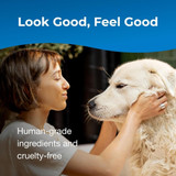 Woman bathing a large white dog and smiling. Text on image reads: ‘Look Good, Feel Good. Human-grade ingredients and cruelty-free.’