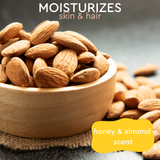 Close-up of almonds in a wooden bowl, accompanied by the text: 'moisturizes skin and hair, honey & almond scent'