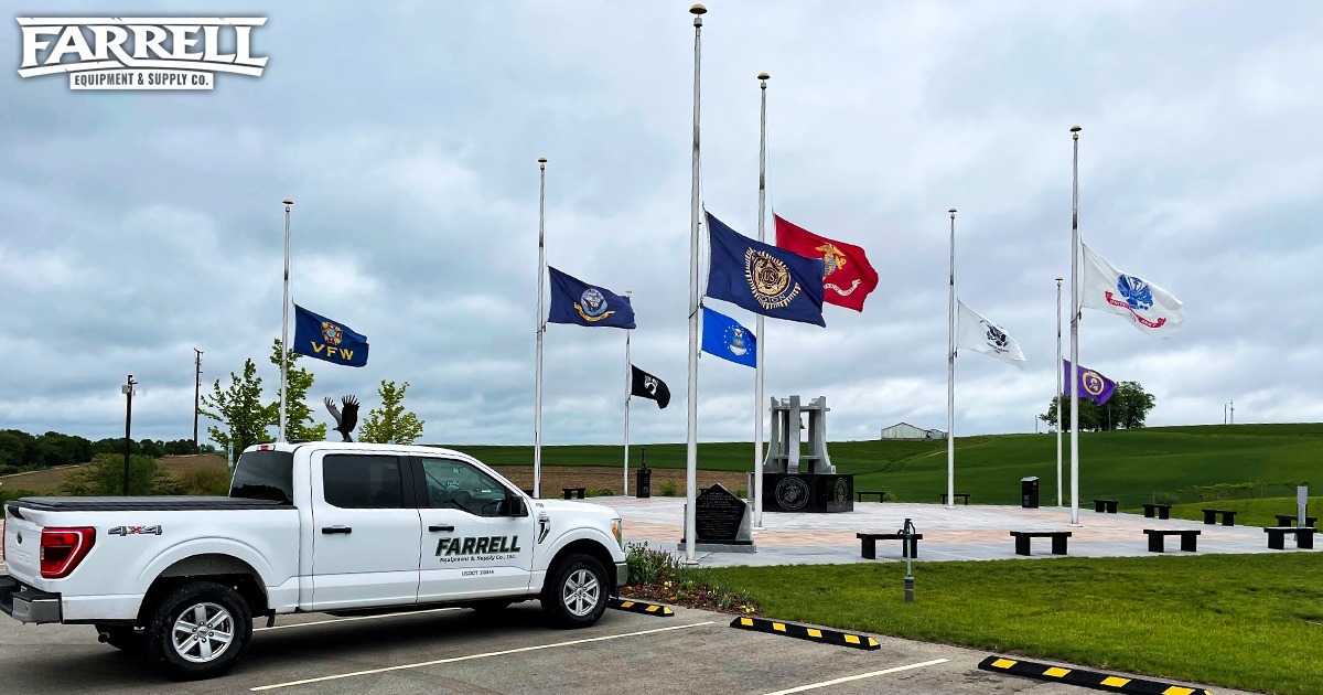 Farrell truck parked in front of flags