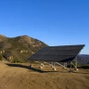 Ground-mounted solar panel array installed on a galvanized steel racking system in a rugged hillside landscape