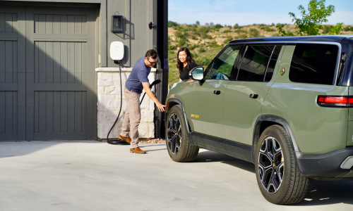 Two people charging their Rivian with an Emporia EV charger.