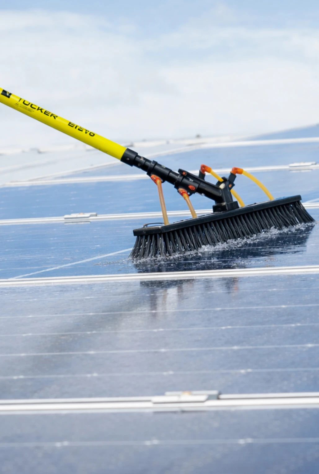Tucker water fed pole cleaning solar panels on roof.