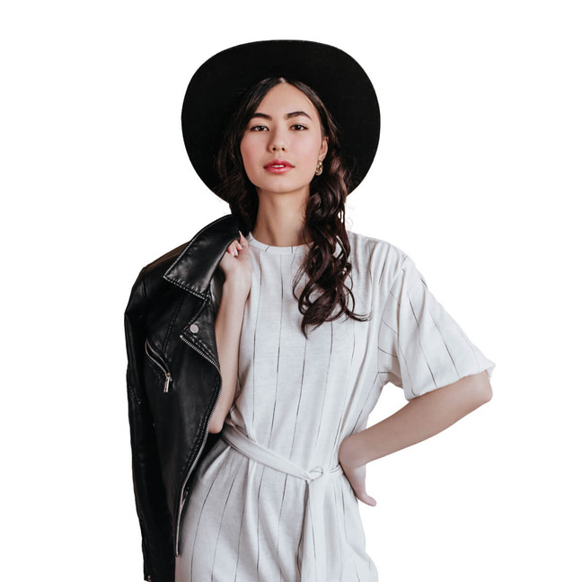 woman white dress with hat holding leather jacket