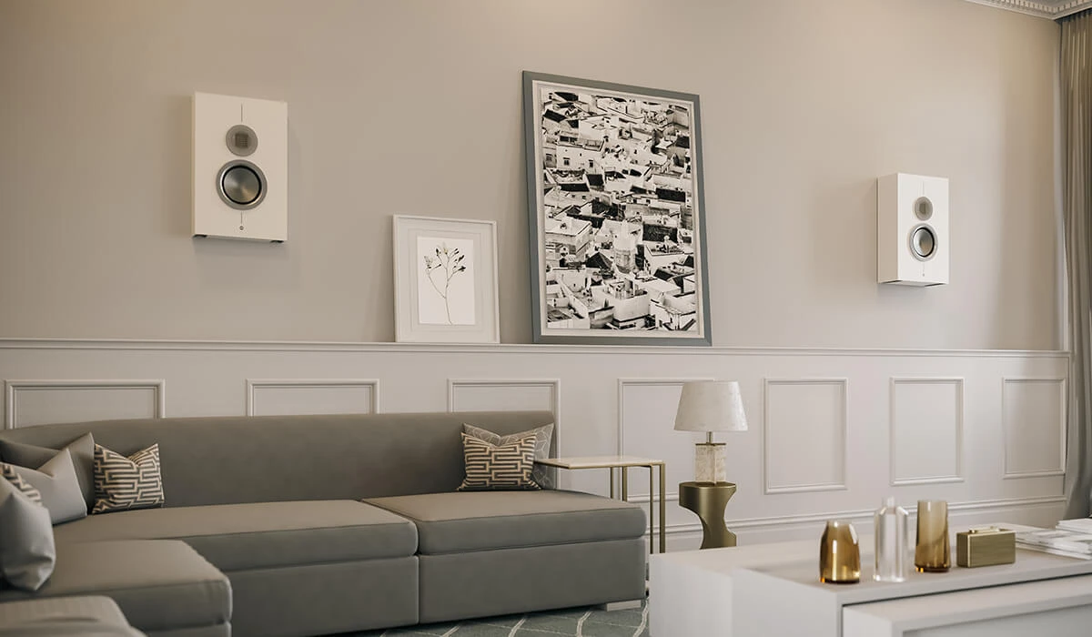 Wall-mounted surround speakers above a sofa