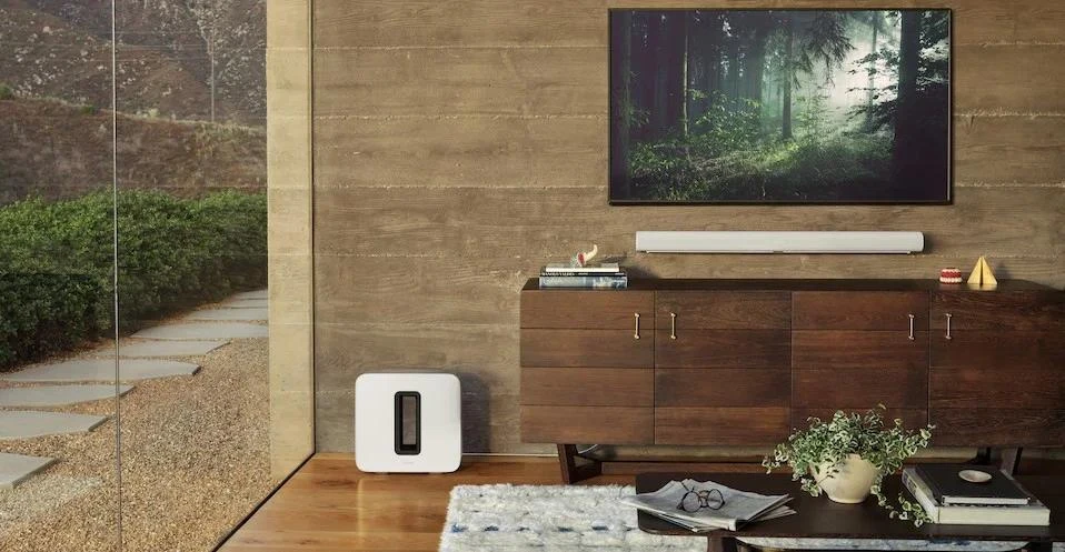 Wall-mounted television with white Sonos soundbar and subwoofer