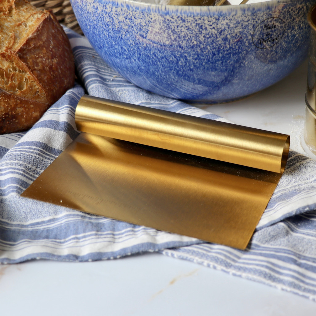 Gold dough scraper marble cotton blue strip proofing cloth with blue portuguese bowl and artisan sourdough loaf