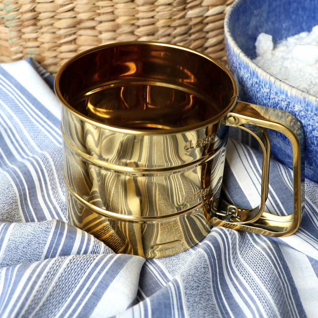 Shiny retro flour sifter vintage kitchen tools blue and white background with basket