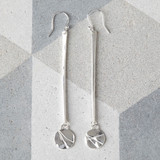Statement earrings with long bar of silver and textured disc.
