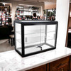 Black glass countertop display case for rent, shown on retail counter with lock and shelves, ready for use at events