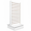 White double-sided slatwall tower on rectangular base, horizontal grooves for hooks and shelves, angled front view