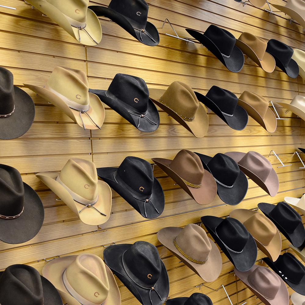 slatwall panel with hat holders, displaying cowboy hats