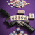 The Bounty Hunter Playing Card Deck lies spread out on a purple poker table alongside a firearm and poker chips. Product sold by Midwest Industries.