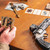 Lifestyle photo of the Bounty Hunter Series Smith & Wesson Rail System 6" L Frame next to someone holding the Bounty Hunter card deck on a table. Product made by Midwest Industries.