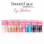 Sweet Face Minerals bulk loose eyeshadows displayed in pink resealable pouches, showcasing a range of shimmering shades including ivory, gold, copper, rose, turquoise, purple, and deep black against a clean white background.