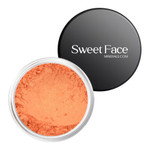 An open jar of Sweet Face Minerals Sassy Eye Shadow showcasing a finely milled, warm pumpkin-orange shimmer pigment with subtle golden sparkle, paired with a sleek black branded lid.