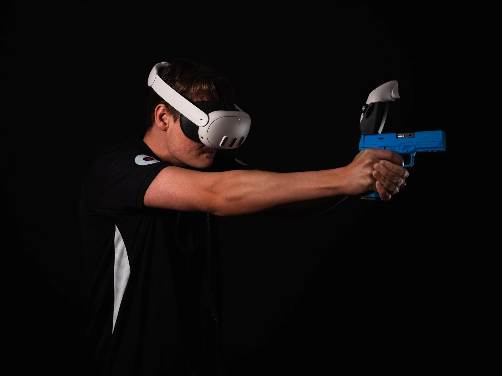 Shooter aiming a GAIM pistol trainer in virtual reality