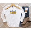 Gildan Teacher Sweatshirt, embroidered sweatshirt with Teacher in Multiple  thread colors and the grade taught embroidered on the word teacher, this lifestyle photo shows how this shirt would look on a white sweatshirt.
