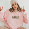 Pink NICU nurse embroidered sweatshirt with floral “NICU” lettering and “helping little ones bloom” text on front.