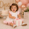 Personalized girl's first birthday outfit with monogram embroidery, ruffle sleeves, and matching bloomers.
