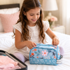 Young girl packing a blue floral bee toiletry bag for an overnight trip