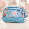 Personalized floral bee toiletry bag displayed in a soft upscale boutique setting