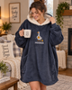 A woman wearing a navy knitting hoodie blanket with an embroidered goose design