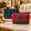 Red and green plaid waxed canvas clutch bags displayed in an upscale holiday boutique