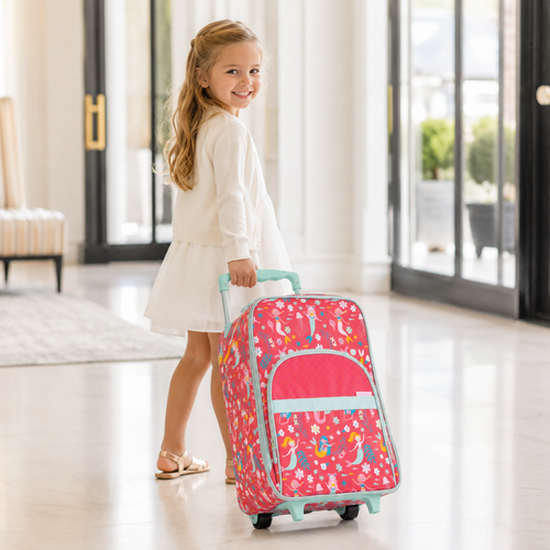 Little girl pulling a coral mermaid rolling suitcase with aqua trim