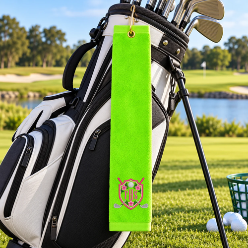 Neon green golf towel with pink floral golf crest and FHS monogram hanging from a black and white golf bag.