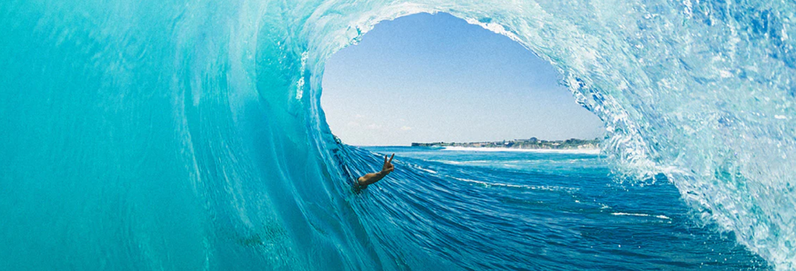 Surfer Body Surfing in a wave holding peace sign
