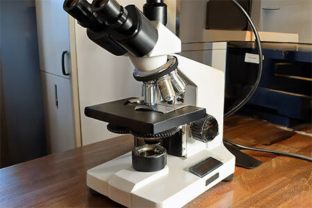 Clean home workspace arranged with microscope and slides ready for study