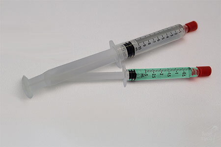 Spore syringe and liquid culture syringe side by side illustrating the two main inoculation media