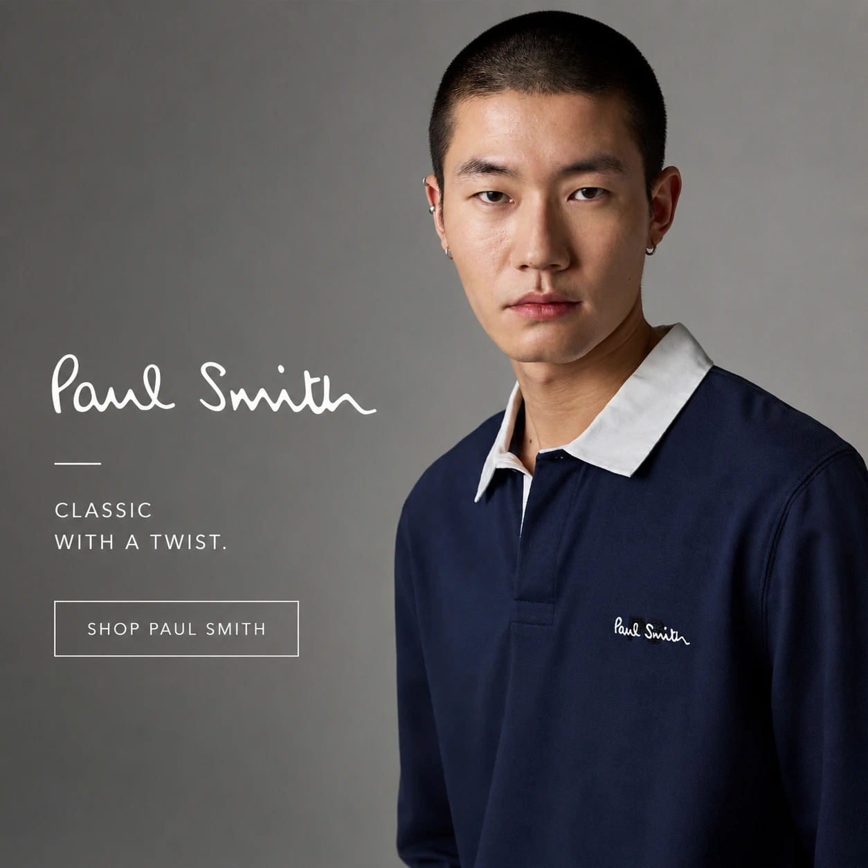 Paul Smith navy blue polo shirt with signature stripe collar detailing and dark denim jeans.