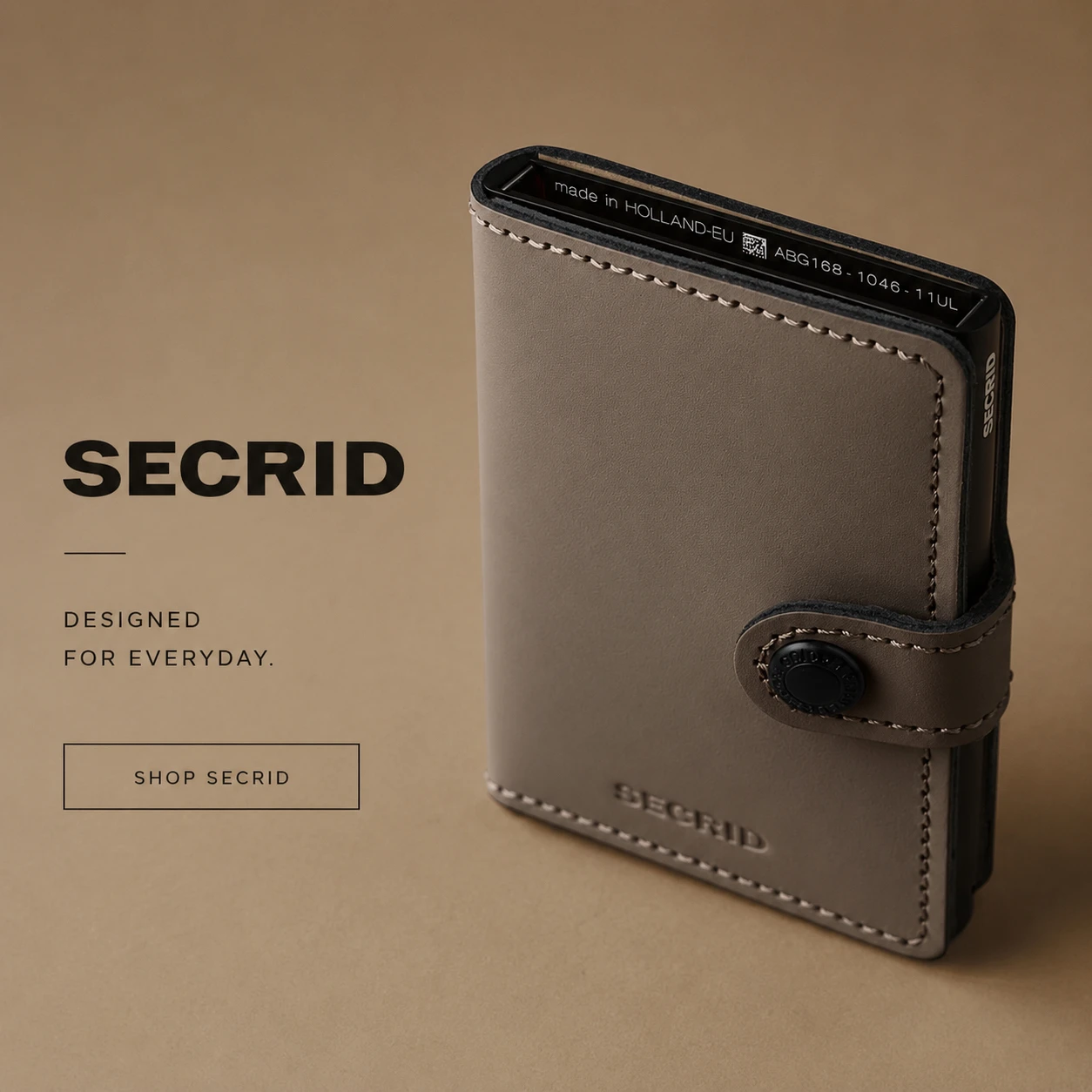 Secrid Miniwallet with a textured geometric pattern held in a lifestyle setting featuring a round table, crystal glass, and fountain pen.