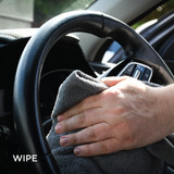 steering wheel being wiped with clean microfibre cloth