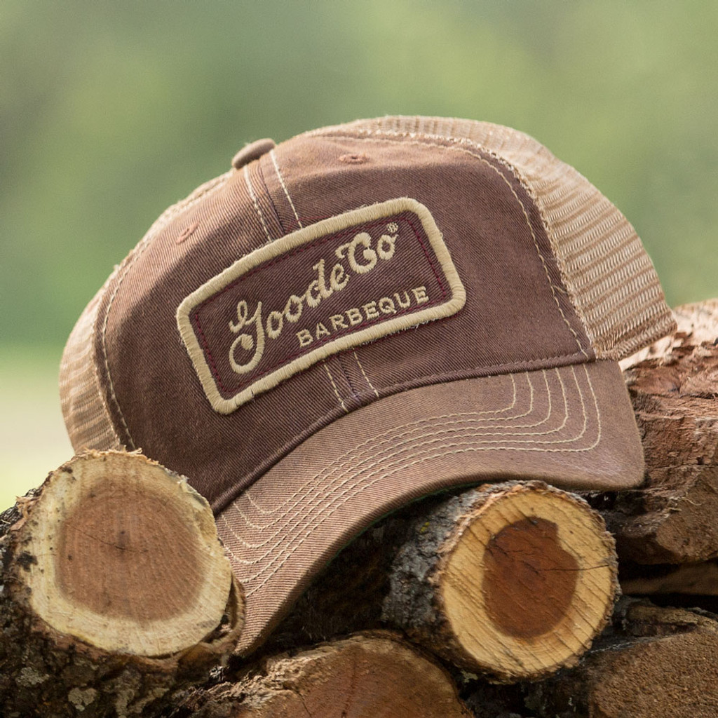 Goode Co's vintage-looking burgundy trucker hat resting on Texas mesquite wood.