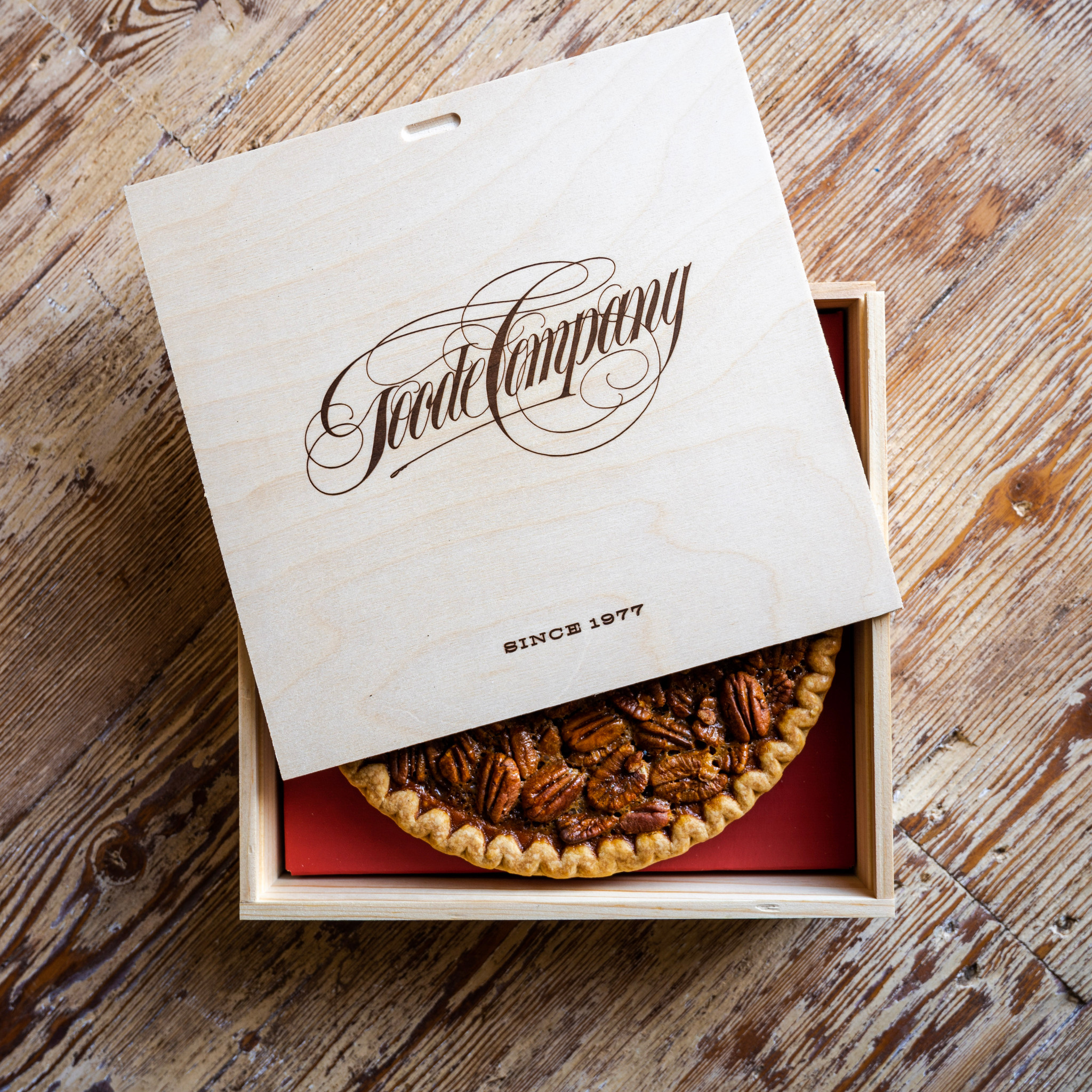 Pecan pie in a wooden box with the lid that shows the name Goode Company written in iconic script logo