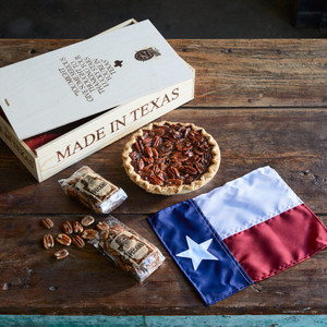 Goode Co's Pure Texas fire-branded wooden gift box, consisting of a personal-sized Brazos Bottom Pecan Pie, bag of Honey-Glazed Pecans, bag of Roasted Salted Pecans, and a mini Texas state flag.