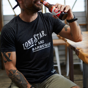 Proud Texan wearing Goode Co's black cotton t-shirt that says "Lone Star & BBQ" in white font.