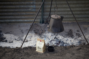 Goode Co Chuckwagon Coffee resting next to fire pit.