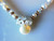Coin pearl and moonstone snowflake cluster on round pearl necklace
