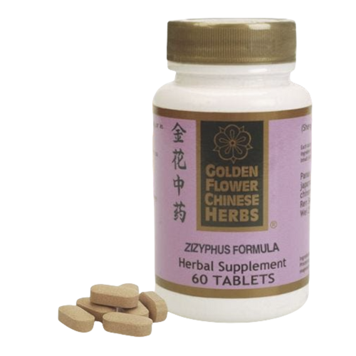 The image depicts a bottle of herbal supplement tablets. The bottle has a cylindrical shape with a creamy, beige-colored screw cap on top. The main body of the bottle is predominantly white, with a printed label wrapped around it.

On the upper left side of the label, there are Chinese characters printed in black, vertically aligned. Just below these characters, in the middle of the label, there's a prominent, bold logo which reads: "GOLDEN FLOWER CHINESE HERBS." The logo includes an illustration of a flower, neatly centered above the brand's name.

Further below the logo, in larger, bold purple letters, the specific product is identified as "ZIZYPHUS FORMULA." Underneath this, in a smaller font size, it is further specified as an "Herbal Supplement." At the very bottom of the label, the quantity of the product is stated as "60 TABLETS."

To the right of the bottle, five beige-colored, oblong-shaped tablets are displayed, suggesting the content of the bottle.