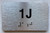 APT# 1J SILVER Braille Sign
