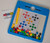 Magnetic Drawing Board
All the fun of magnetic mosaic, but no mess! All the pieces are contained in the board.
Slide and match the coloured discs into position with the magnetic wand to create colourful pictures or your own unique designs


THe doard has a clear plastic cover to prevent the discs from getting lost.


Design cards slide into the board to help you create designs
Includes Board, magnetic wand and 7 double sided picture cards.