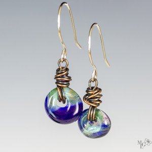 Beautiful blue glass runs into soothing green in a peaceful rhythm and blend of colors making a magical pair of dangle earrings