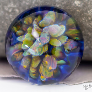 Vibrant textures of greens and purples floating above a dark blue pool. This 20mm lampwork glass bezel bead makes you want to dive into it's depths. Vibrant textures of greens and purples floating above a dark blue pool. This 20mm lampwork glass bezel bead makes you want to dive into it's depths.
