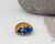 15mm round glass cabochon. the top pattern is a blue floral implosion and the background looks like a golden orange tye die pattern