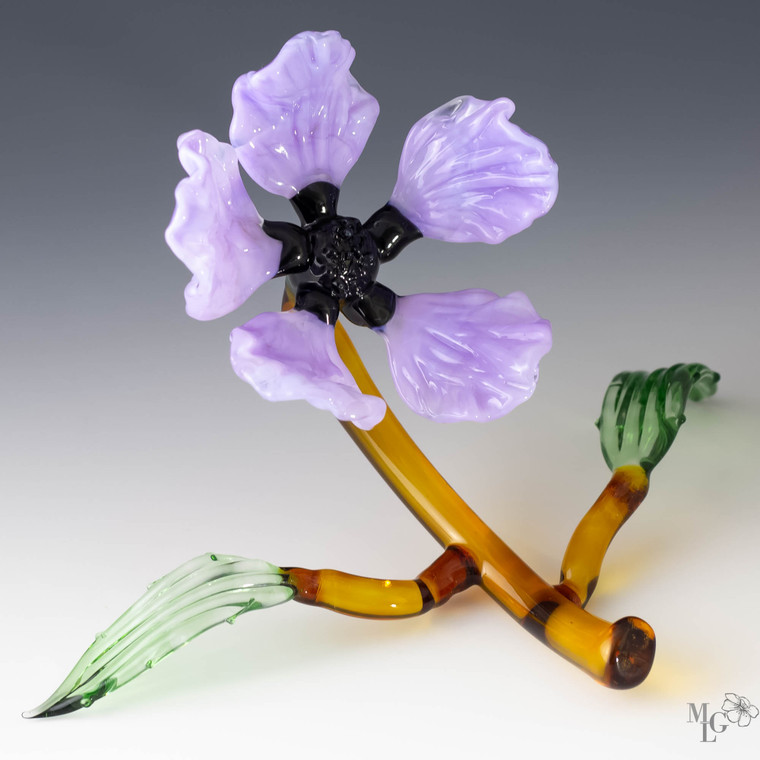 Carefree purple glass wildflower on an amber branch with two supporting green leaves. This sculpture is fresh both in color and design. Playful and ready to grace your home with it's charm